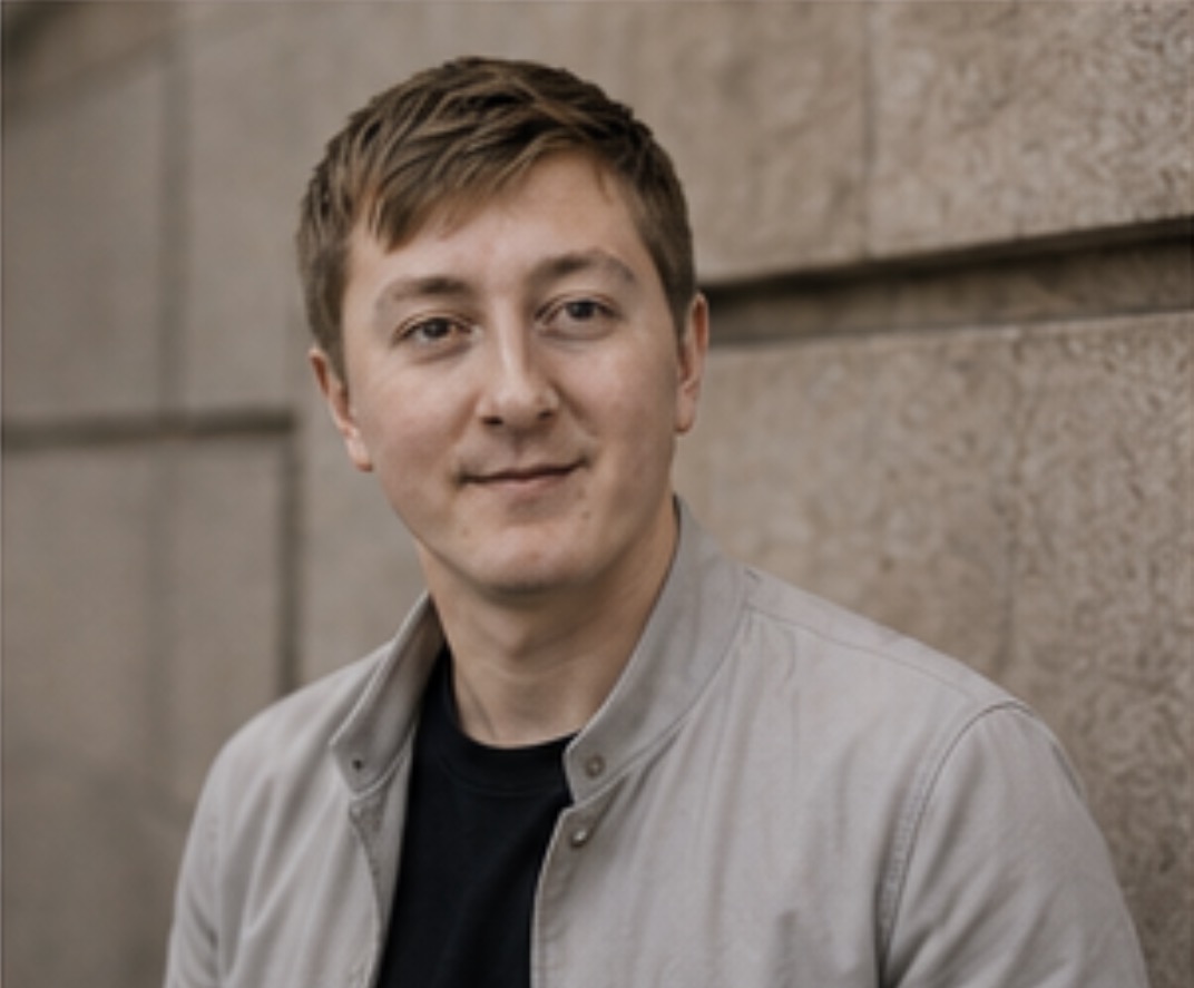 Moritz Zinecker outdoors beside a stone wall