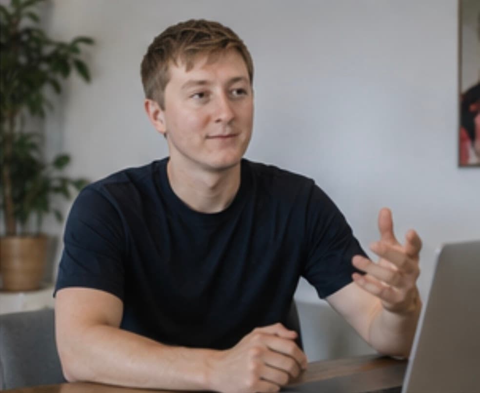 Moritz Zinecker speaking at a table with an open laptop