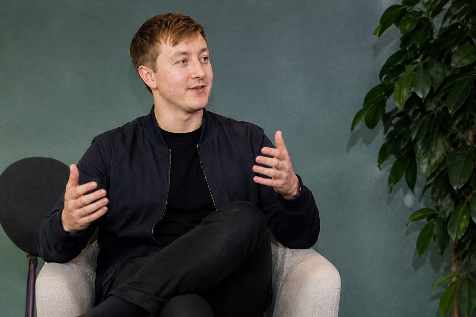 Moritz Zinecker seated in an armchair and gesturing during an interview